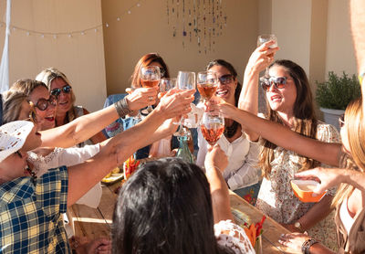 Female friends doing celebratory toast at building terrace
