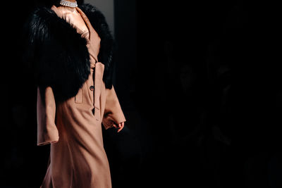 Classy fashion details of long brown autumnal coat with fur, women's fashion cloth concept