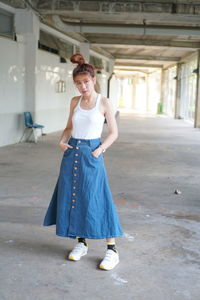 Portrait of young woman standing at home