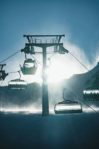 People skiing underneath ski lift in stormy conditions, kitzsteinhorn ski resort, austria