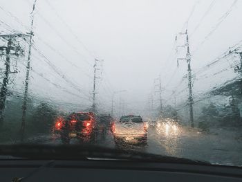 Cars on road seen through wet window during winter