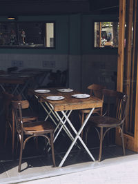 Empty chairs and tables at sidewalk cafe