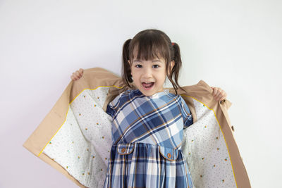 Portrait of cute girl standing against white background