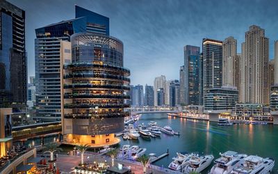 Illuminated modern buildings in city against sky