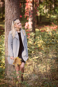 Woman standing against tree 