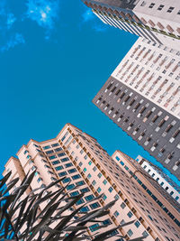 Low angle view of modern buildings against blue sky