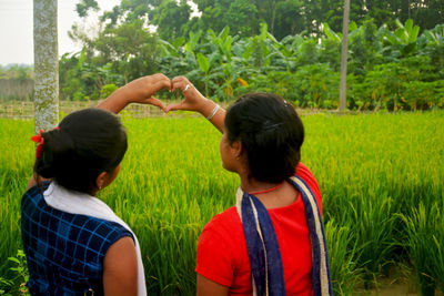 Rear view of two people on field