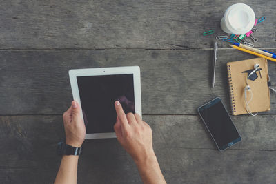 Low section of person holding smart phone on table