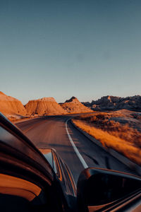 Road passing through landscape against clear sky