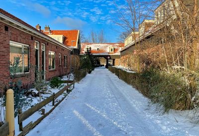 Street amidst houses against sky during winter