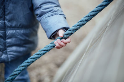 Close-up of man holding rope