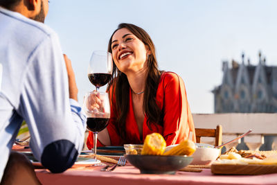 Portrait of young woman having food on table