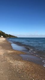 Scenic view of beach against clear blue sky