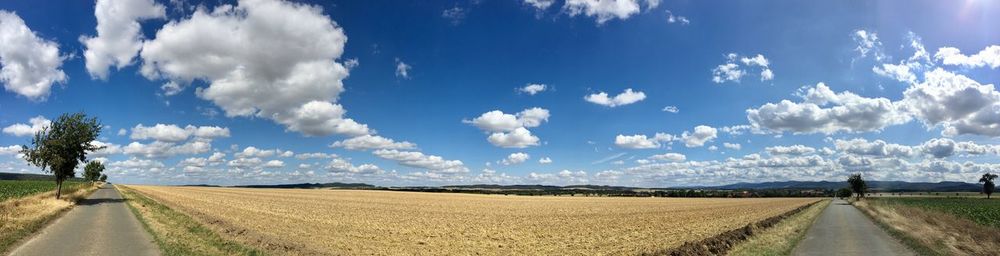 Panoramic view of agricultural field against sky