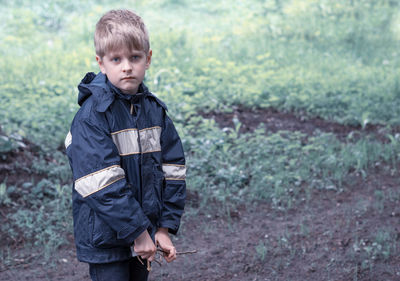Portrait of boy wearing raincoat in forest