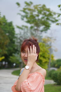 Portrait of woman standing against trees