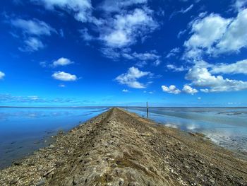 Scenic view of beach against blue sky