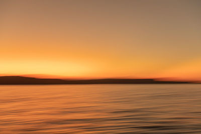 Scenic view of sea against clear sky during sunset