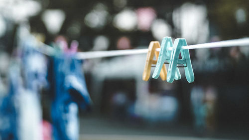 Close-up of clothespins hanging on rope