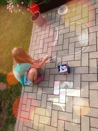 High angle view of girl playing on footpath