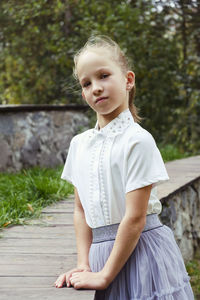 Portraits of a little girl with gathered blonde hair on a summer day in the park