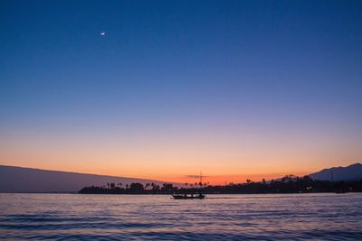 Boat sailing on sea against sky during sunset