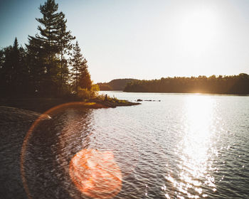 Scenic view of lake against clear sky during sunset