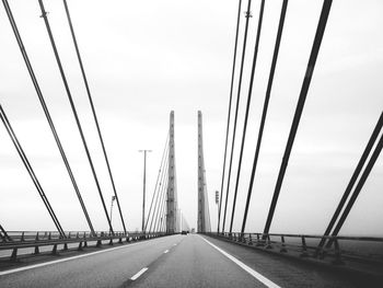 Cables and towers of bridge against sky