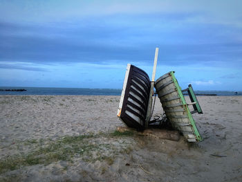 Chairs on beach against sky