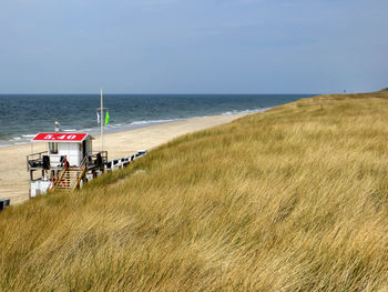 Scenic view of north sea against clear sky with lifeguard hut
