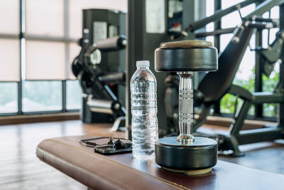 Dumbbell and water bottle on seat at gym