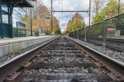 Railroad tracks by trees against sky