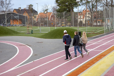 School friends walking across school sports grounds