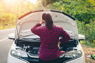 Rear view of woman standing in car