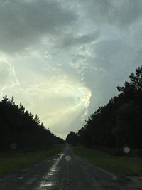 Road amidst trees against sky