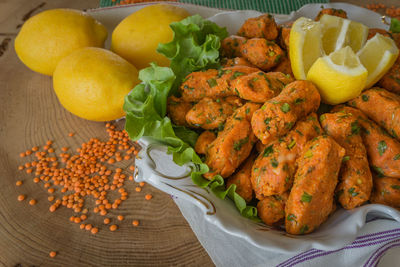 Red lentil balls served with lemons