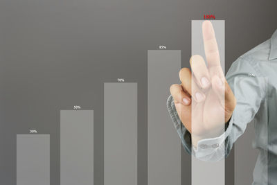 Digital composite image of businessman touching graph on device screen