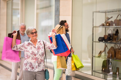 Smiling woman enjoying while walking with shopping bags