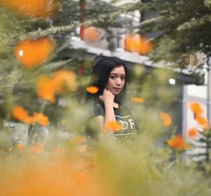 Full length of woman standing against orange plants