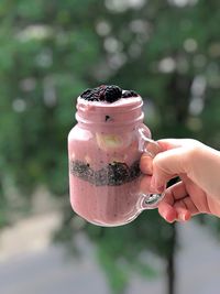 Cropped hand holding smoothie in jar