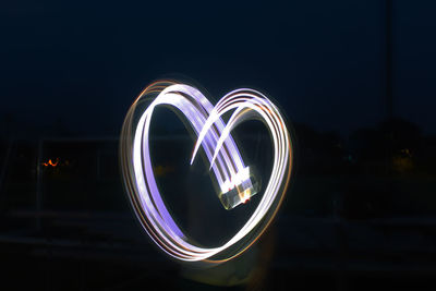 Low angle view of illuminated lighting equipment against sky