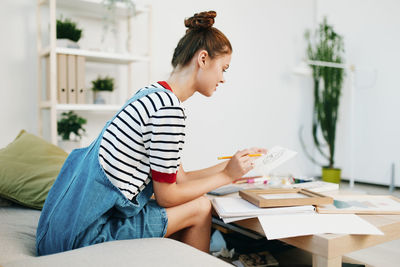 Side view of mother using laptop at home