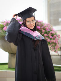 Portrait of woman wearing graduation gown