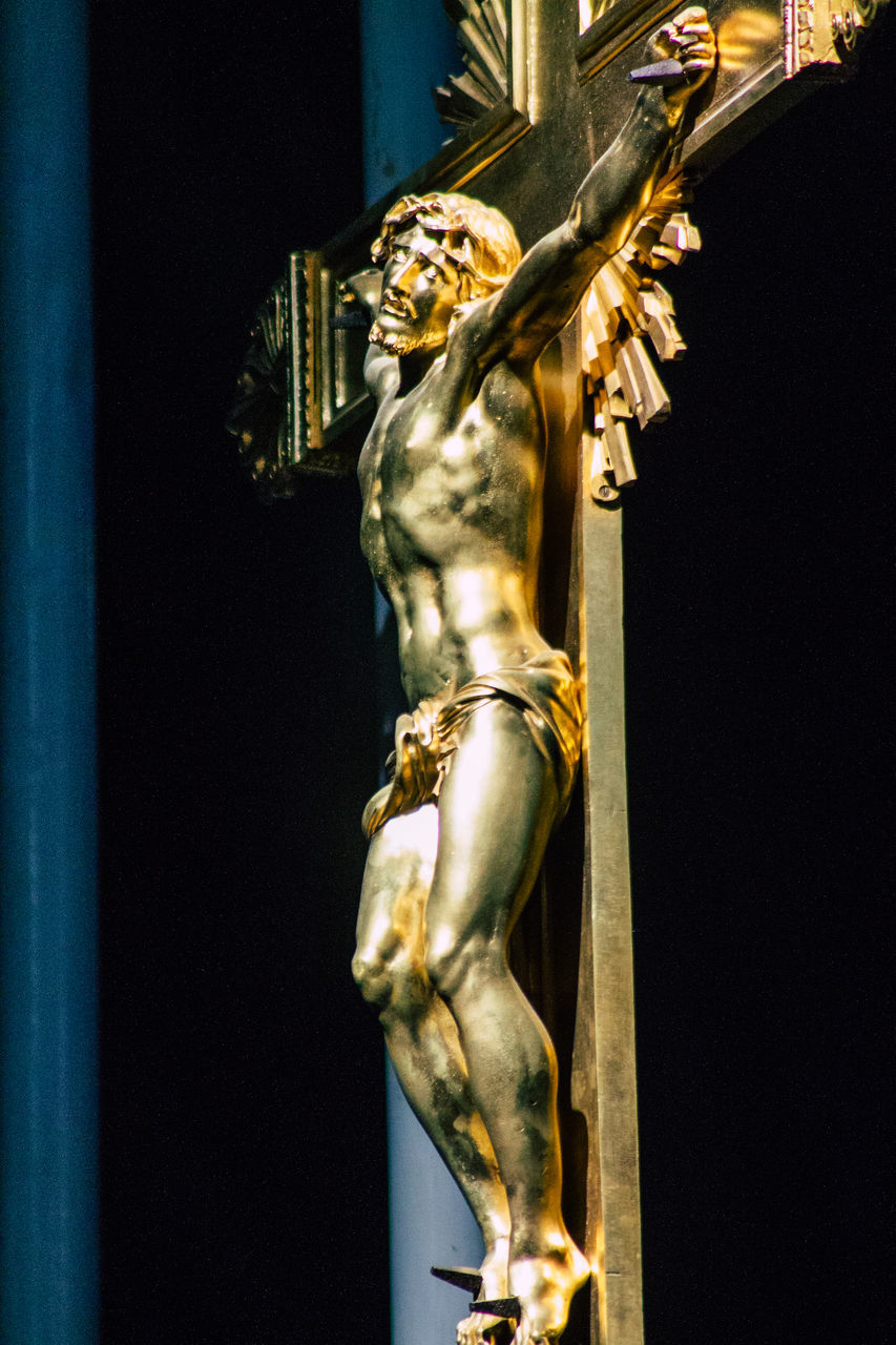 CLOSE-UP OF STATUE AGAINST BLACK BUILDING