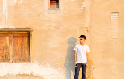 Full length of man standing against wall in building