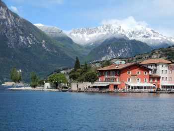 Houses by buildings and mountains against sky