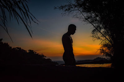 Silhouette woman standing against sky during sunset