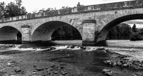 Arch bridge over river against sky