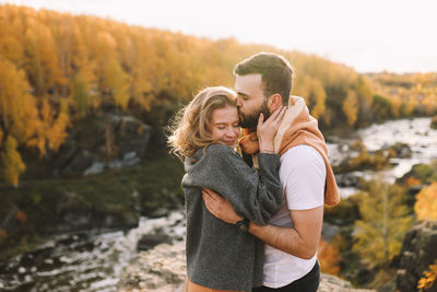 Happy people in love are travel hike in nature in the autumn forest. romantic trip to countryside