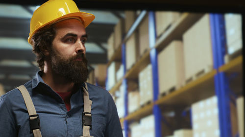 Portrait of young man standing in factory